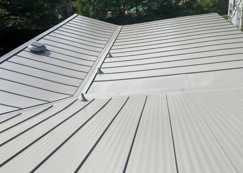 Solar attic fan installed on a metal roof for Roof Ventilation in Huron